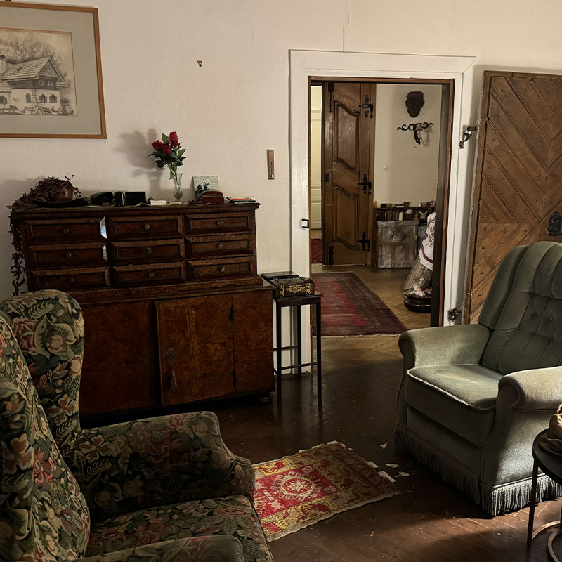 Vorher: Zimmer mit schwerer Kommode und Polstermöbeln aus einer Verlassenschaft vor der Wertermittlung und Räumung.