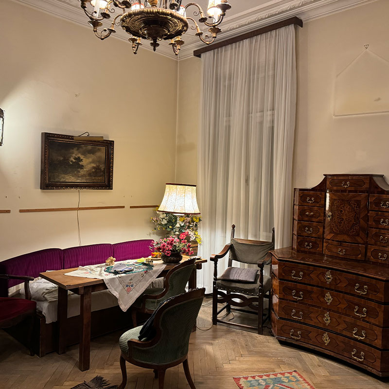 Vorher: Wohn- und Essbereich mit antikem Sekretär und Kronleuchter vor der Räumung durch den Antiquitätenhändler.