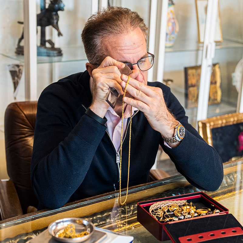 Seriöser Goldankauf Wien: Experte Haldenwang bei der Wertermittlung von Goldschmuck und Goldmünzen nach tagesaktuellem Börsenkurs.