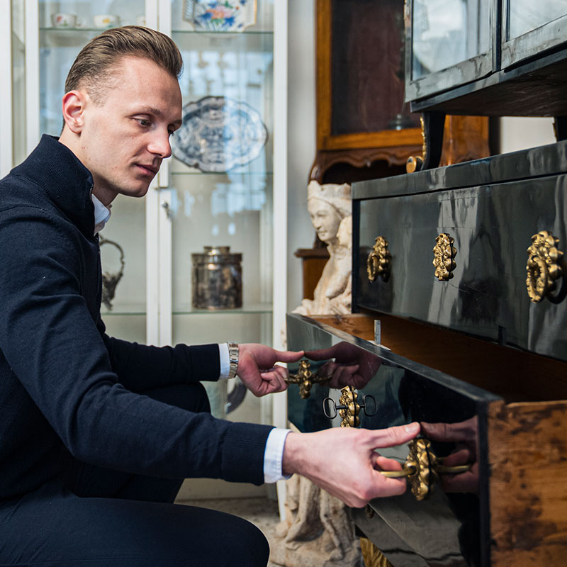 Möbel Ankauf Wien: Erfahrener Antiquitätenhändler bei der Begutachtung und Wertschätzung antiker Holzmöbel und Einrichtungsgegenstände.